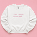 Oops I bought another book white jumper with pink embroidered text