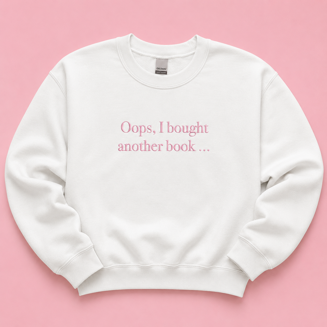 Oops I bought another book white jumper with pink embroidered text